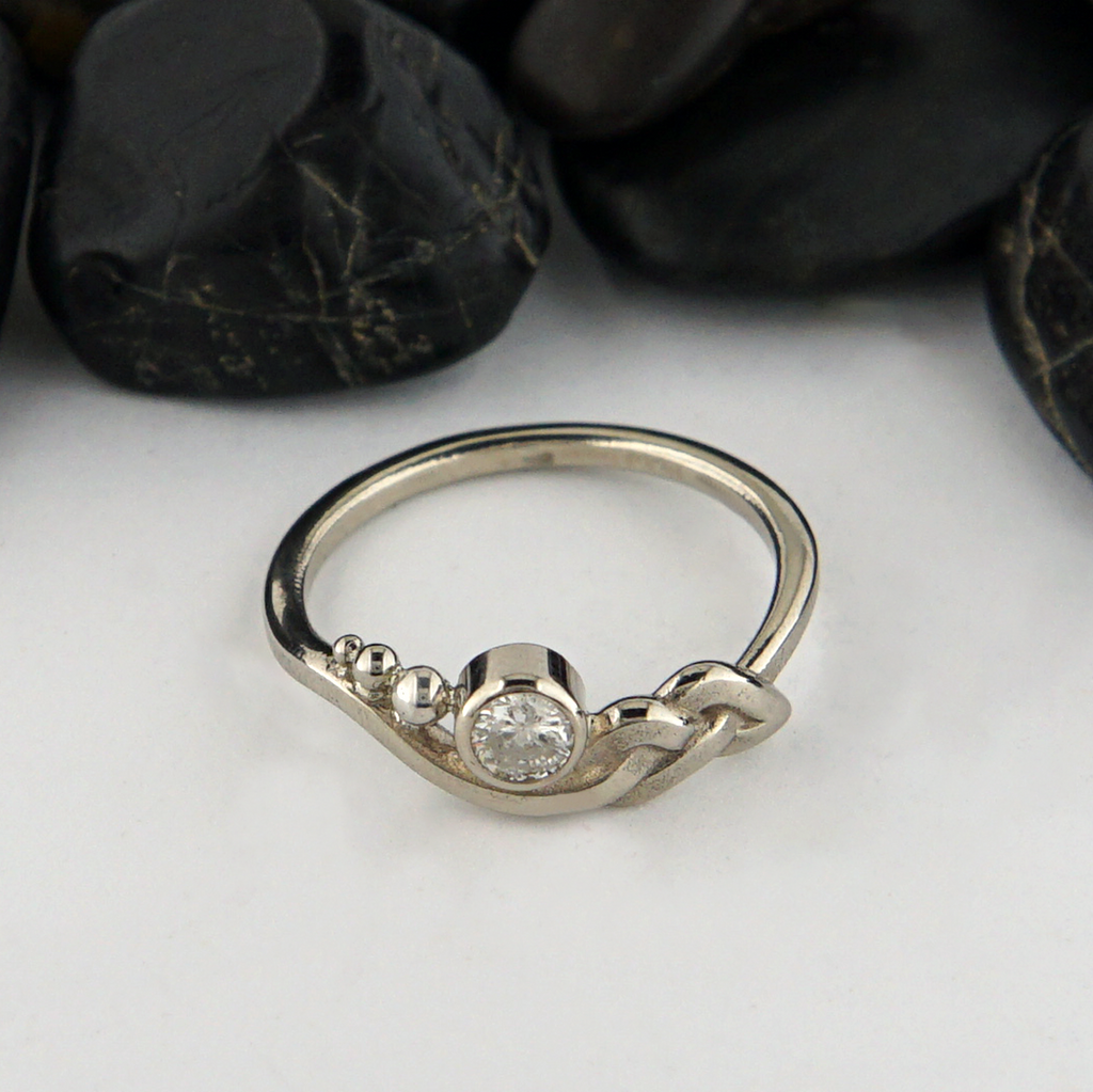 Custom whimsical knot ring in 14K White Gold with a bezel set 1/3 CT diamond. 