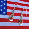 Silver earrings with red gemstones on an American flag background