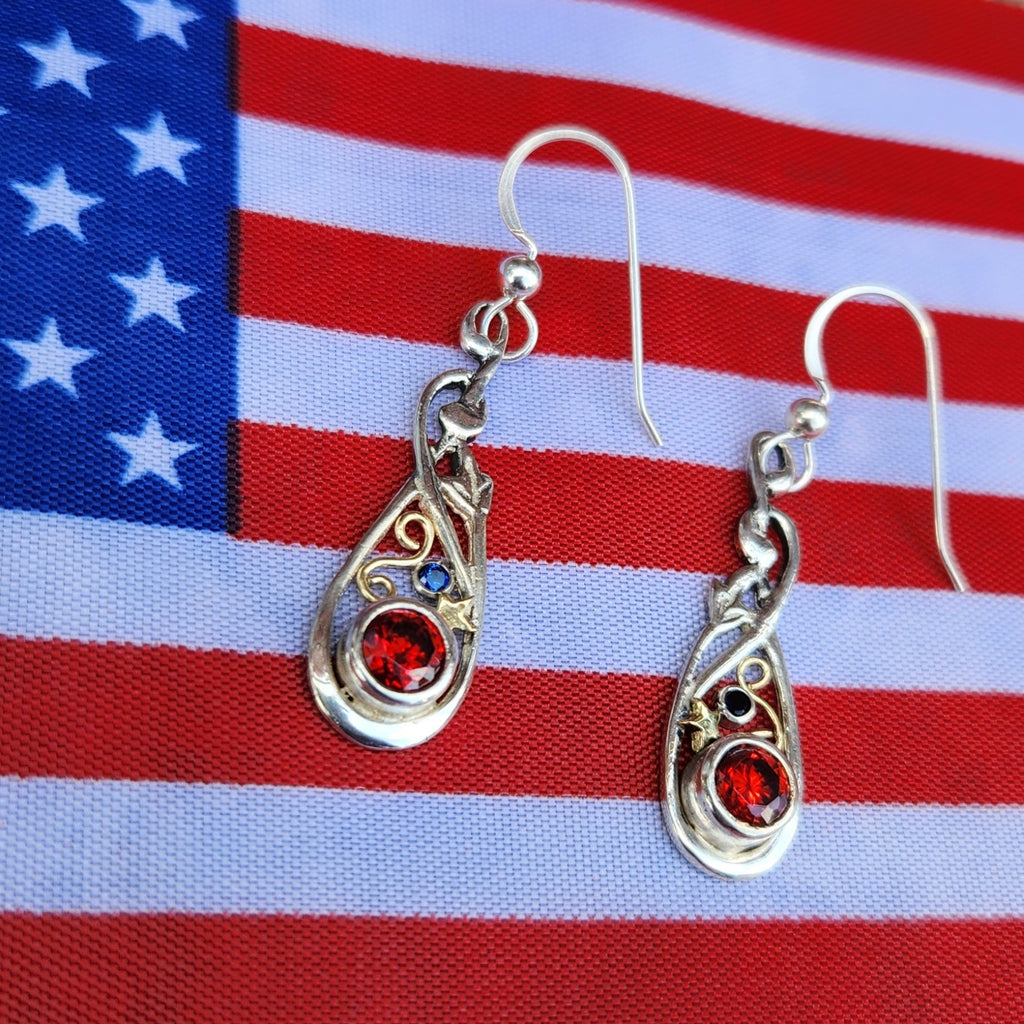 Silver earrings with red gemstones on an American flag background