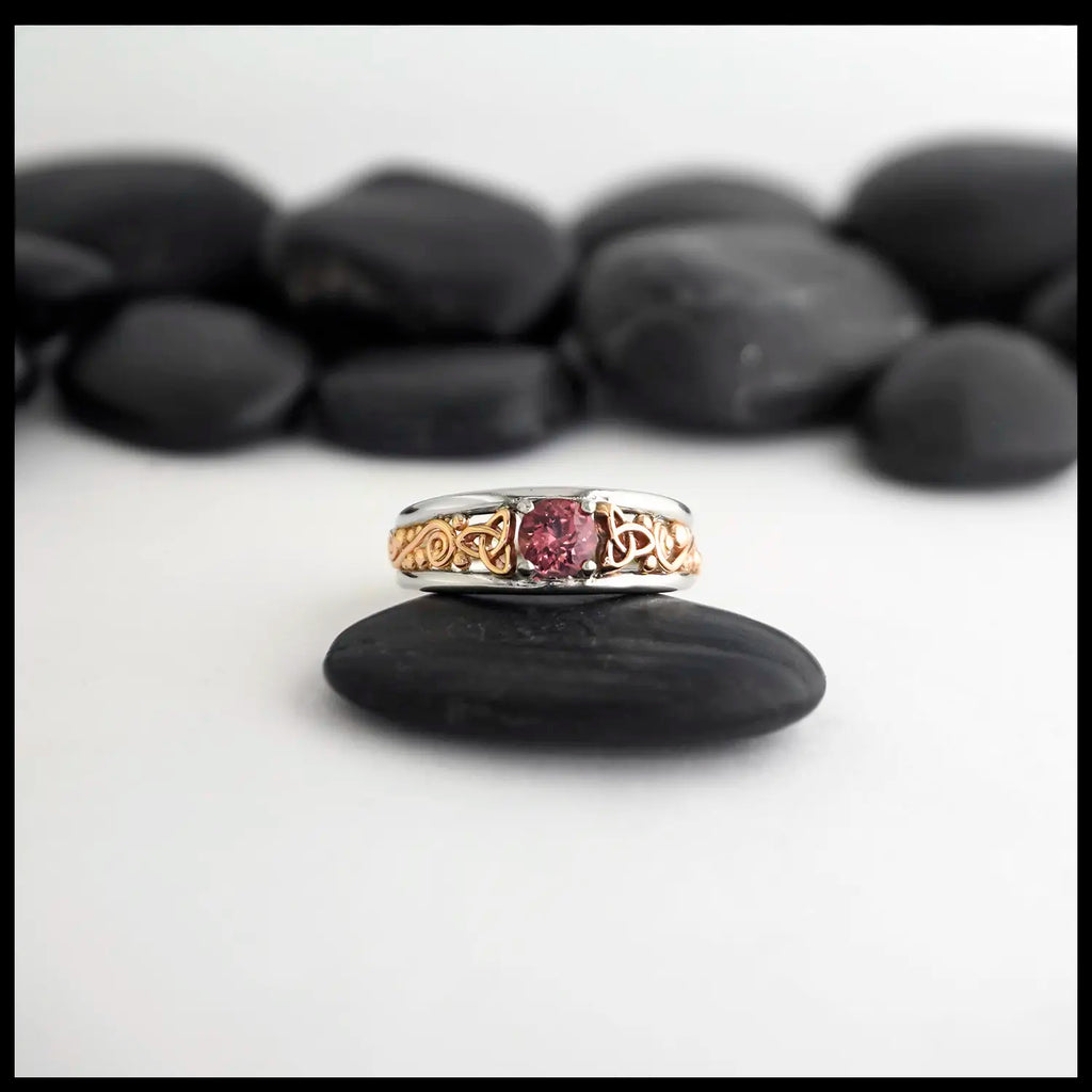 14K Rose Gold frame ring with 14K White Gold Rails,Set with a malaya garnet on a black stone with a white background