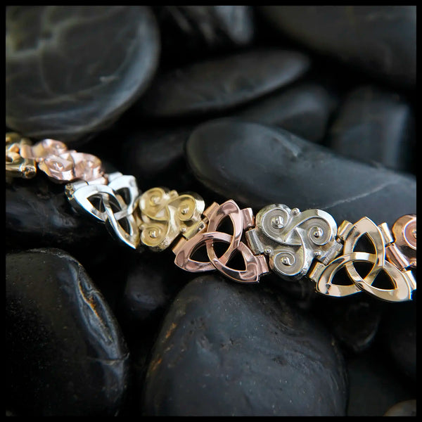 Alternating Link bracelet with tri-color 14k gold trinity and triskele knots.