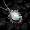 Moonstone pendant set with Blue Diamonds, Ruby, Tsavorites, and Blue Zircon in Sterling Silver and 14/18K Gold
