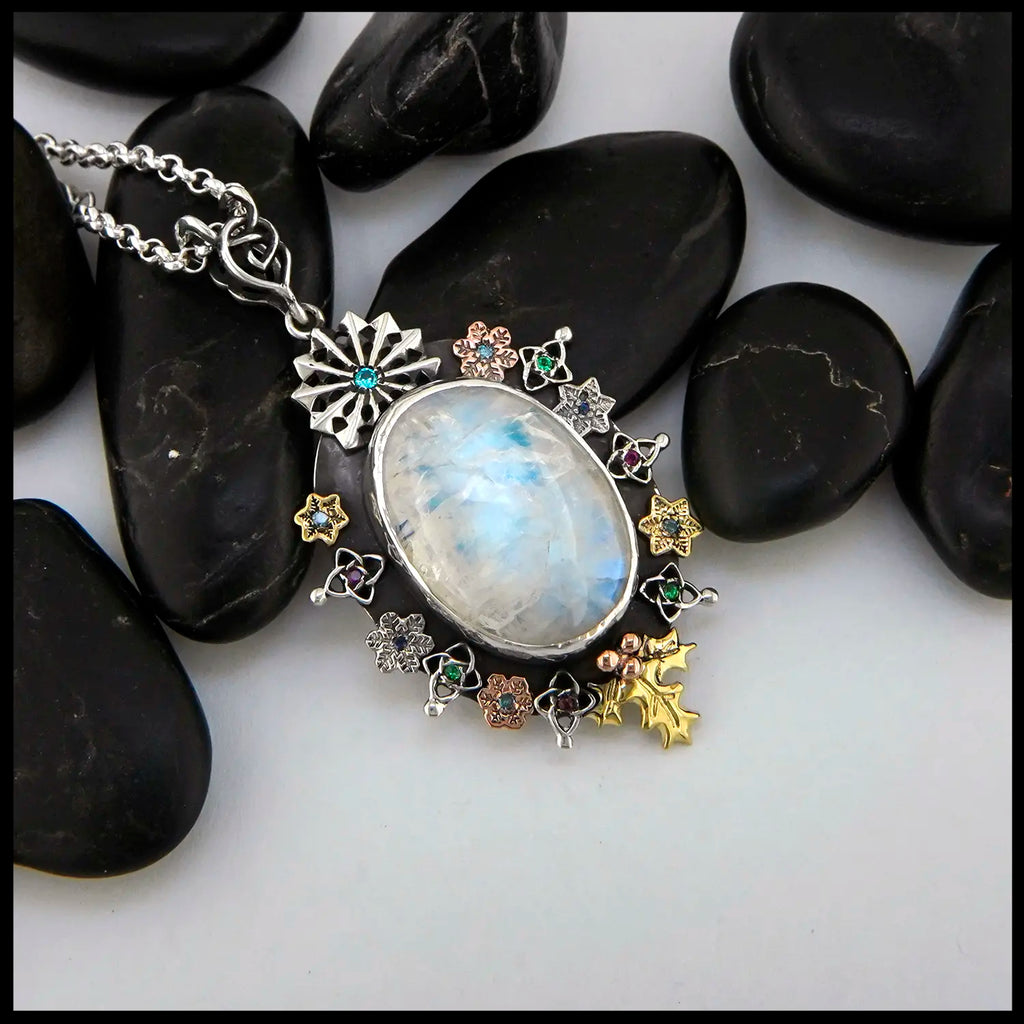 Moonstone pendant set with Blue Diamonds, Ruby, Tsavorites, and Blue Zircon in Sterling Silver and 14/18K Gold