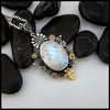 Moonstone pendant set with Blue Diamonds, Ruby, Tsavorites, and Blue Zircon in Sterling Silver and 14/18K Gold