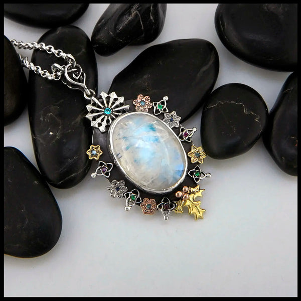 Moonstone pendant set with Blue Diamonds, Ruby, Tsavorites, and Blue Zircon in Sterling Silver and 14/18K Gold