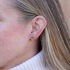 Triquetra post earring in 14K gold with sapphire, worn on the ear