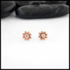 Rose gold flower-shaped earrings with a central Diamond on a white background