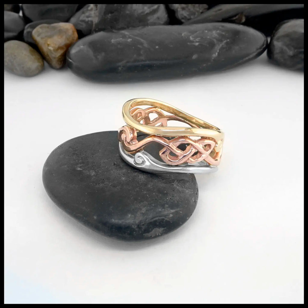 Three-toned ring on a black stone with a white background. Size 7 1/2.