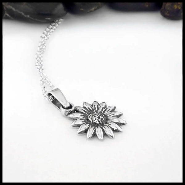 Silver sunflower pendant necklace on a white background