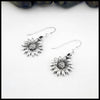 Silver sunflower earrings on a white background