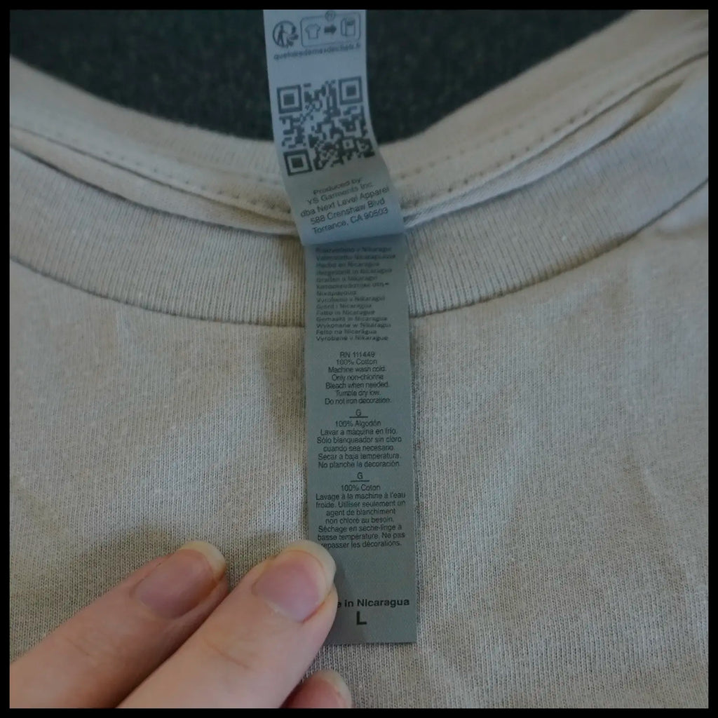 Close-up of a clothing tag with washing/ handling care text and a QR code