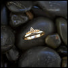 Gold ring with a trinity knot and beading design on dark stones