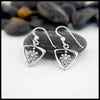 Sterling Silver Triangle Frame earrings with Daisy Design on a white surface with pebbles in the background