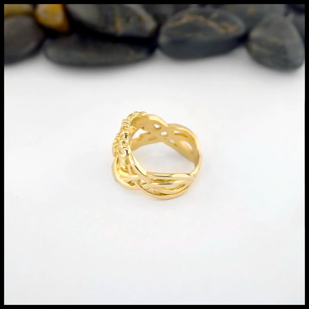 14K Yellow Gold ring with a detailed Scottish Thistle design on a white background with stones in the background
