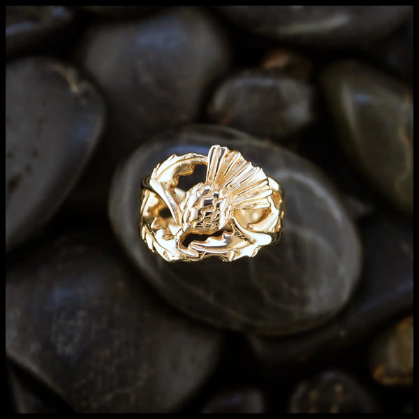 14K Yellow Gold ring with a detailed Scottish Thistle design on a dark stone surface