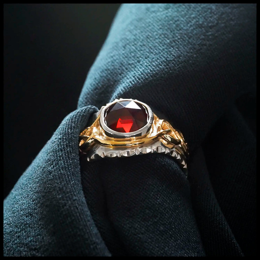 Gold and Silver Mens Garnet ring on cloth background