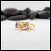 Gold custom frame ring with rose gold, white gold, and yellow gold set with two diamonds and an oval blue sapphire