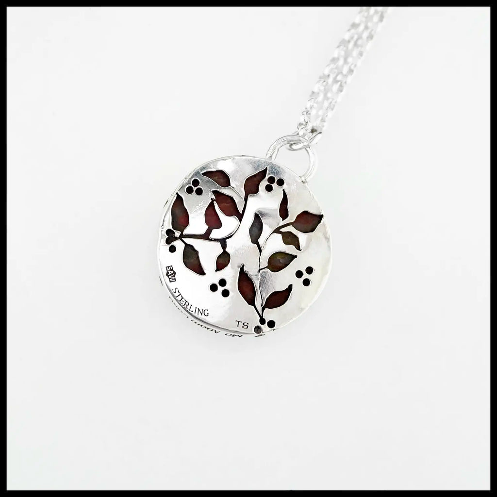 Silver pendant backing with leaf and vine cutouts, revealing the bloodstone through the openings