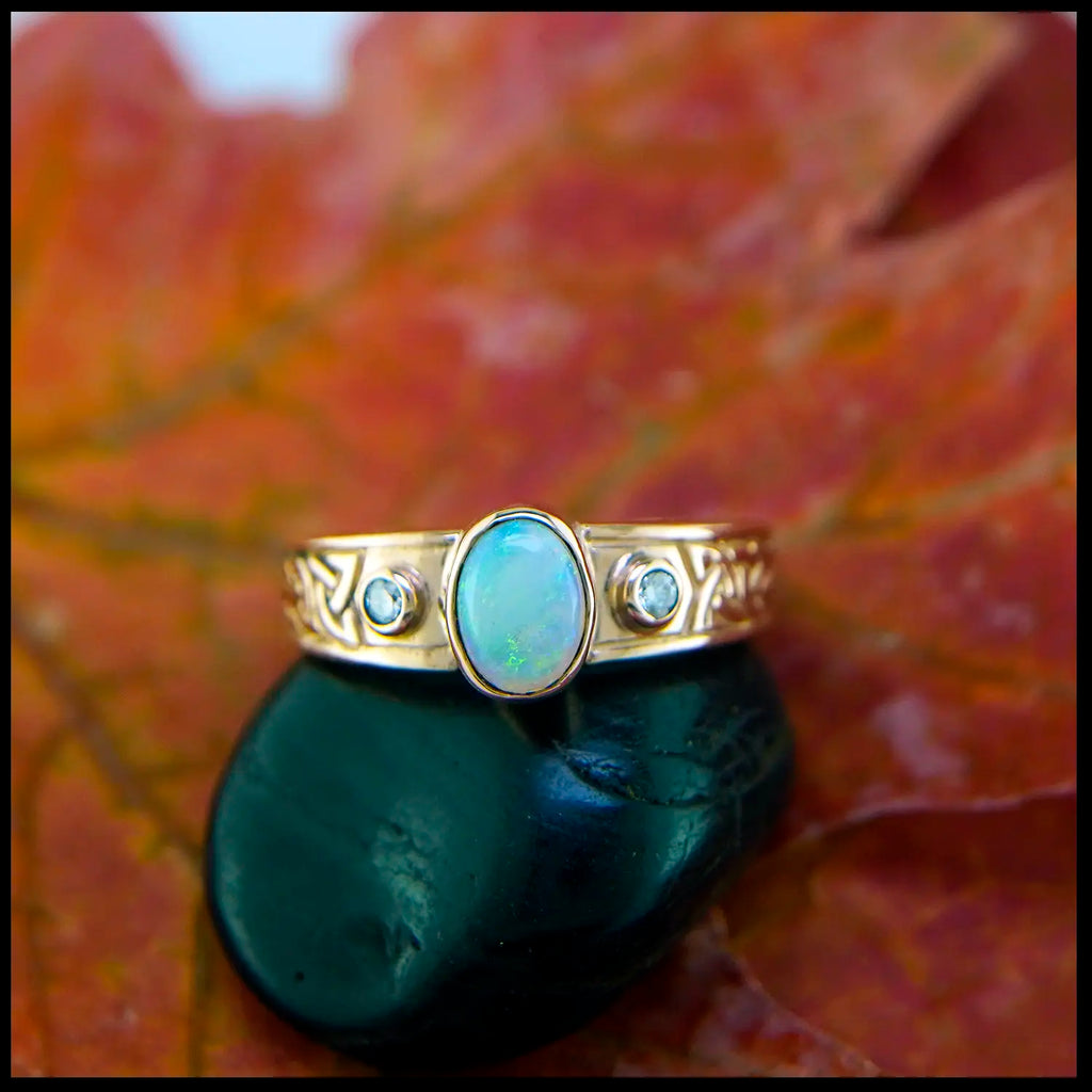 Gold ring with opal stone on a leaf background