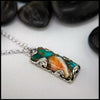 Necklace with a rectangular pendant featuring turquoise and orange colors on a white background.