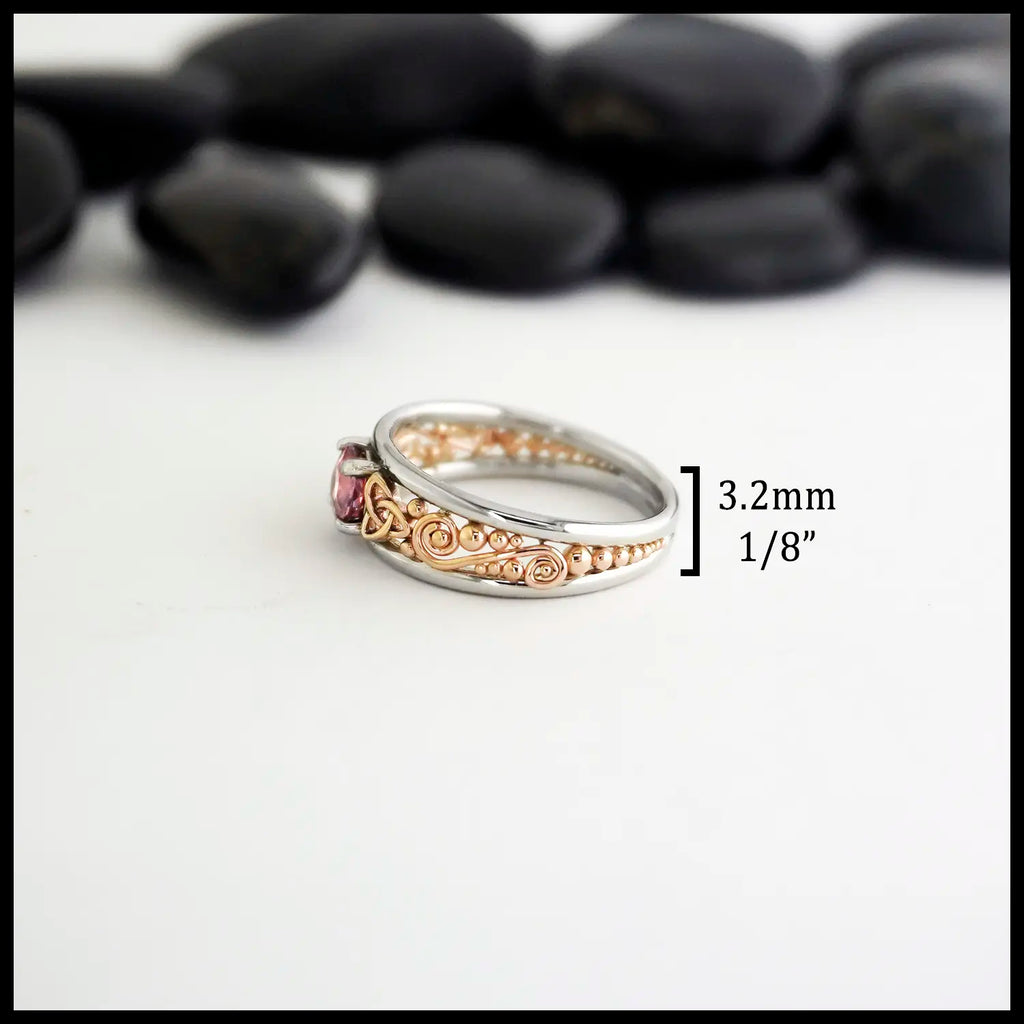 14K Rose Gold frame ring with 14K White Gold Rails,Set with a malaya garnet on a black stone with a white background. The measurements are 3.2mm or 1/8" width of the tapered band.