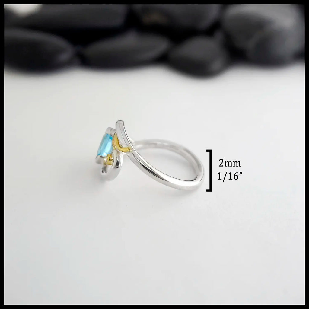 Silver ring with a blue topaz and diamond on a white background. measurements are 2mm or 1/6" band