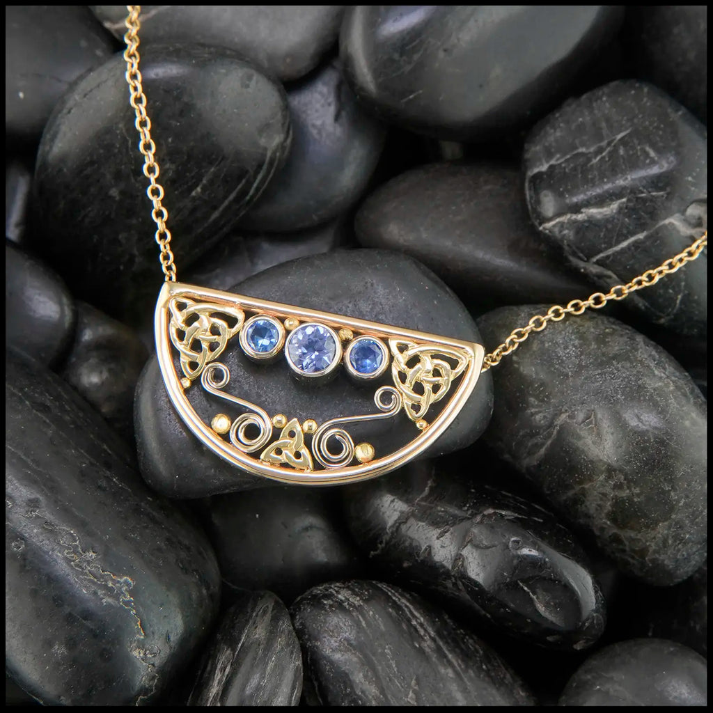 14K Yellow Gold frame pendant on an attached chain, featuring ceylon blue sapphires and 18K gold details.