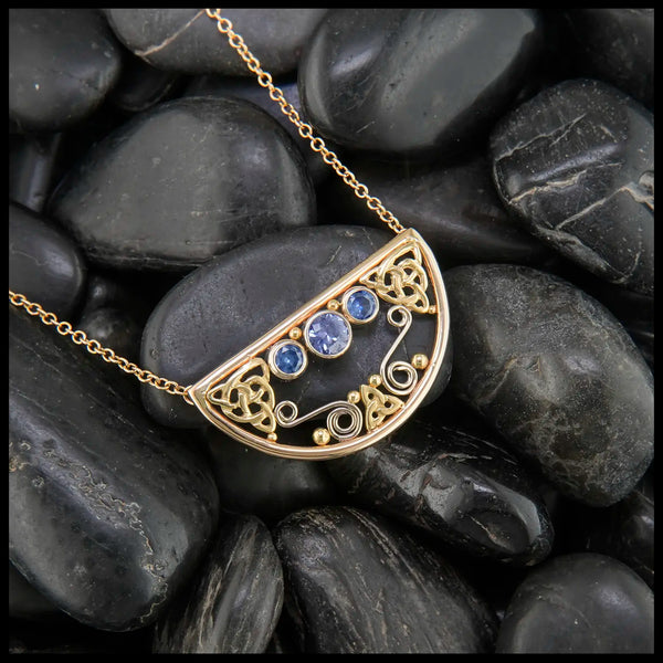 14K Yellow Gold frame pendant on an attached chain, featuring ceylon blue sapphires and 18K gold details.