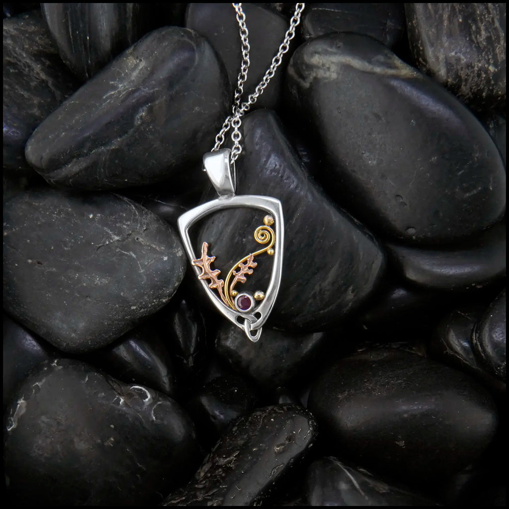 Silver Frame pendant with 14K rose gold oak leaves, 14K yellow gold spirals and beads. set with a 2mm ruby.