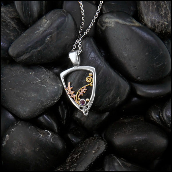 Silver Frame pendant with 14K rose gold oak leaves, 14K yellow gold spirals and beads. set with a 2mm ruby.