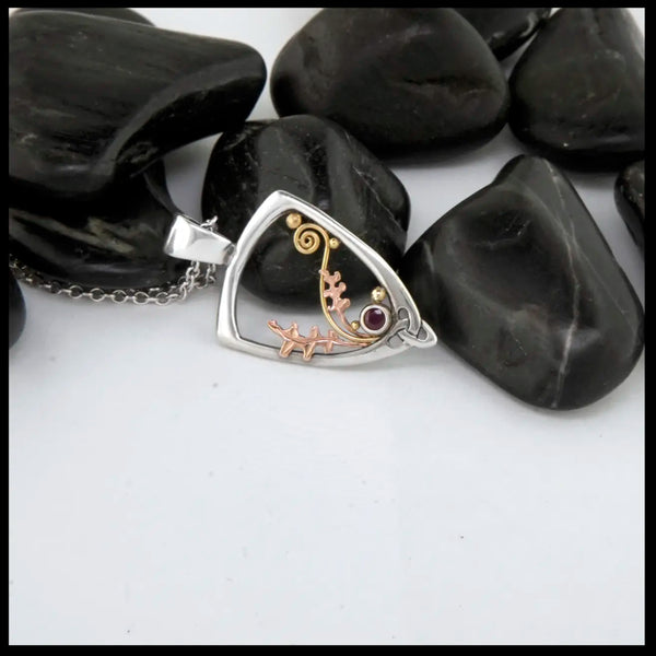 Silver Frame pendant with 14K rose gold oak leaves, 14K yellow gold spirals and beads. set with a 2mm ruby.