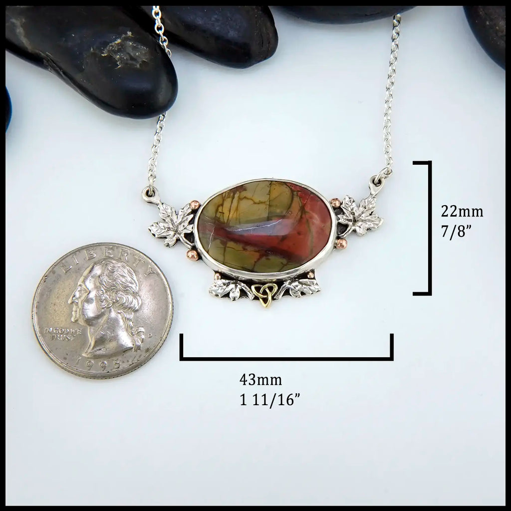 Necklace with a large oval pendant next to a coin for scale on a white background. 22mm by 43mm
