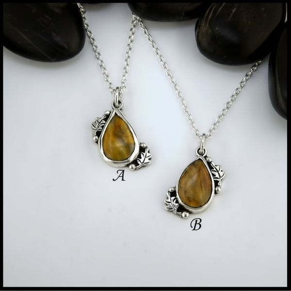 Petrified wood teardrop cabochon set in sterling silver with leaves.