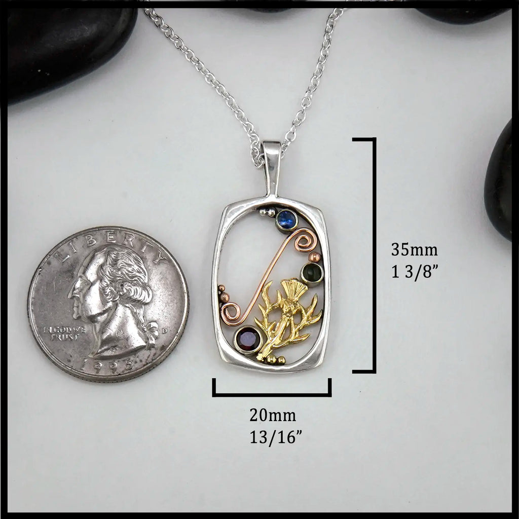 Silver pendant with thistle design and gemstones next to a quarter for scale on a white background 35mm by 20mm