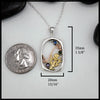 Silver pendant with thistle design and gemstones next to a quarter for scale on a white background 35mm by 20mm
