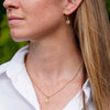 Dainty Josephine's Knot pendant and matching drop earrings in 14K gold with diamonds, worn
