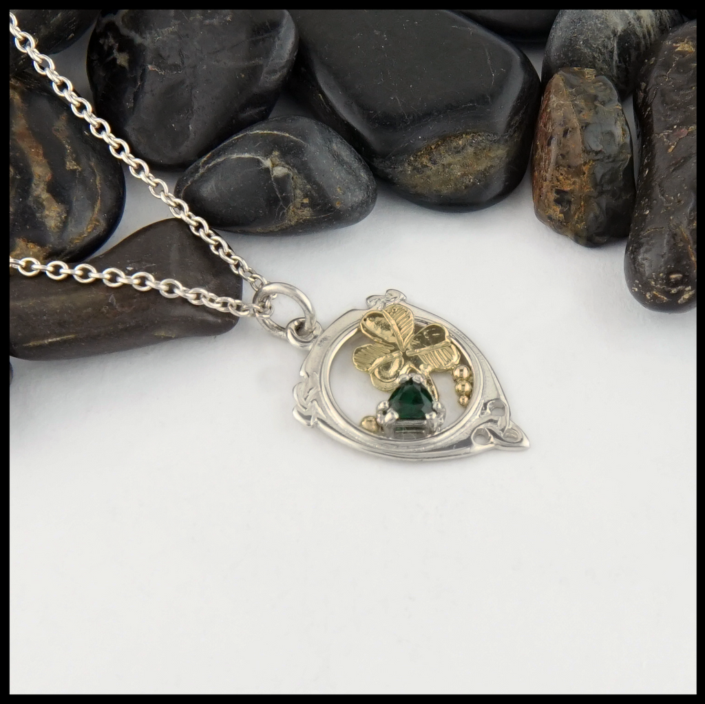 This sterling silver custom pendant has a shamrock design and set with a trilliant Green Tsavorite.