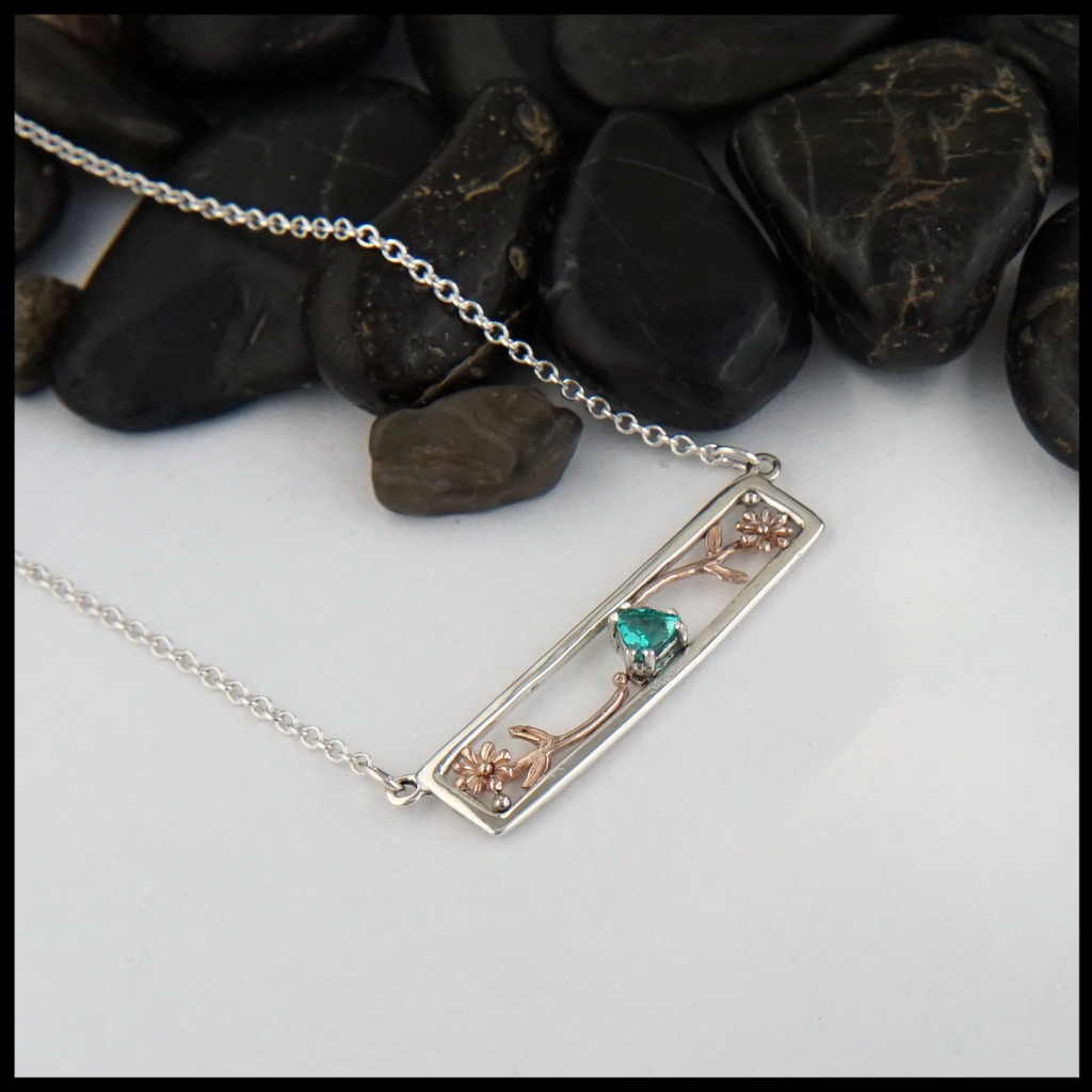 Custom Flower Necklace in Sterling Silver with 14K Rose Gold flowers, set with a green Emerald. 