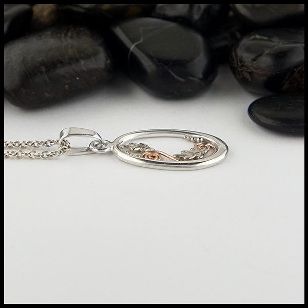 Profile view of Leaf Flourish pendant in Sterling Silver with 14K Rose Gold spirals and  14K White Gold oak leaves and bead accents.