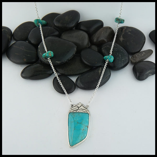 Custom Mountain Turquoise pendant in Sterling Silver, set with a large Turquoise stone. This pendant comes on a 16" cable chain and is set with 4 smaller Turquoise stones along the chain.