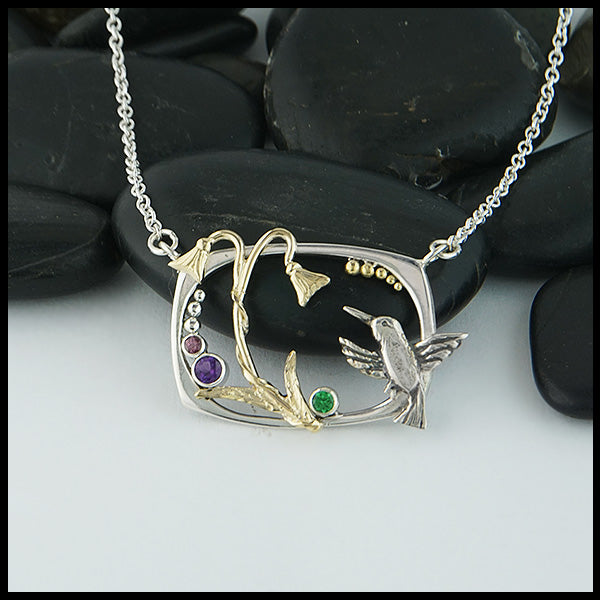 Custom Hummingbird and Flower pendant in Sterling Silver with 14K Yellow Gold Hummingbird, flower, and accent beads, set with an Amethyst, Tsavorite, and Rhodolite Garnet.