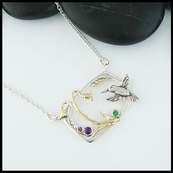 Custom Hummingbird and Flower pendant in Sterling Silver with 14K Yellow Gold Hummingbird, flower, and accent beads, set with an Amethyst, Tsavorite, and Rhodolite Garnet. Shown with an attached cable chain.