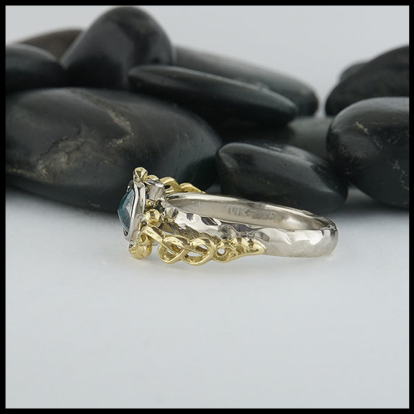 Profile view of 14K White Gold textured band with an 18K Yellow Gold cathedral design, set with a .59CT blue rose cut Diamond and a .06CT accent Diamond. 