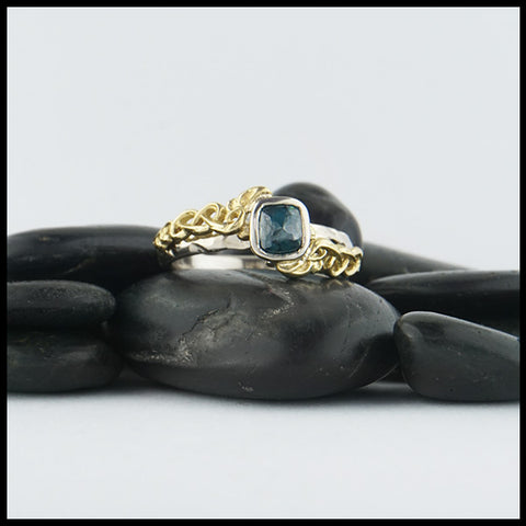 Custom 14K White Gold textured band with an 18K Yellow Gold cathedral design, set with a .59CT blue rose cut Diamond and a .06CT accent Diamond. 
