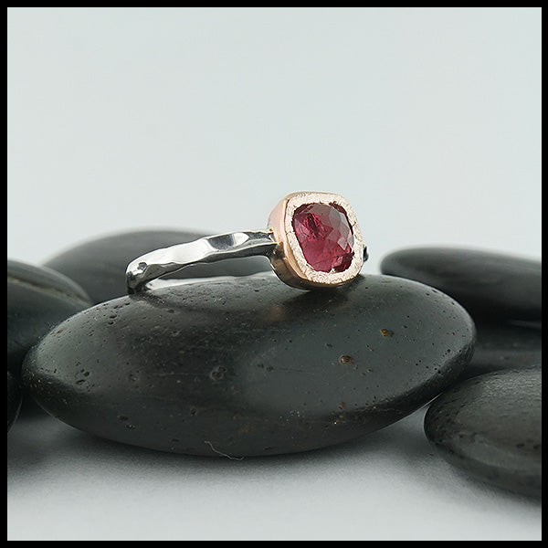Custom, rustic, hand fabricated ring in sterling silver with a textured rose gold bezel, set with a Rose Cut Magenta Tourmaline.