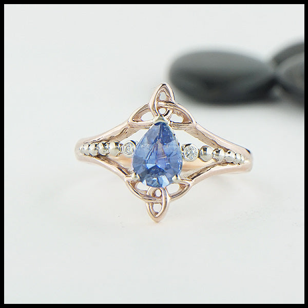 Custom 14K Rose Gold Celtic Trinity Knot ring, set with a genuine 7x5mm Blue Sapphire stone and two .04ct diamonds with 14K white gold details.