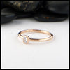 Simple 14K Rose Gold ring bezel set with a 0.09ct Emerald Cut Diamond.