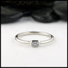 Simple 14K White Gold ring bezel set with a 0.09ct Emerald Cut Diamond.