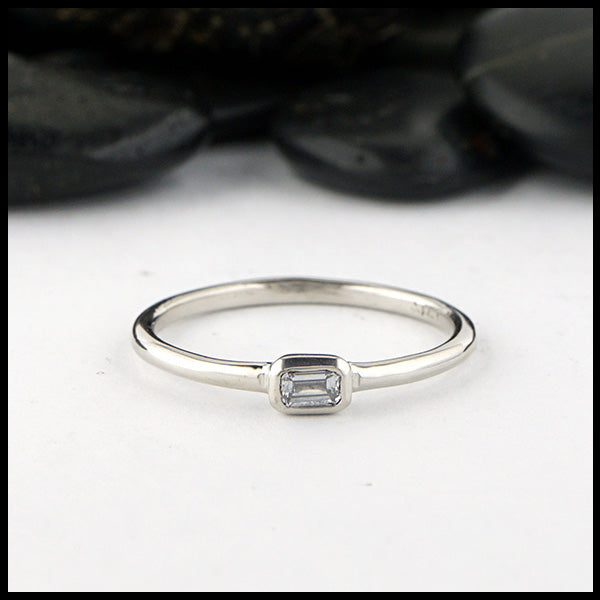 Simple 14K White Gold ring bezel set with a 0.09ct Emerald Cut Diamond.