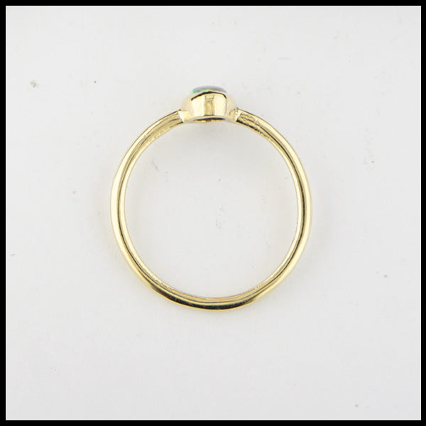Profile view of simple 18K Yellow Gold ring bezel set with a 0.36ct oval opal.